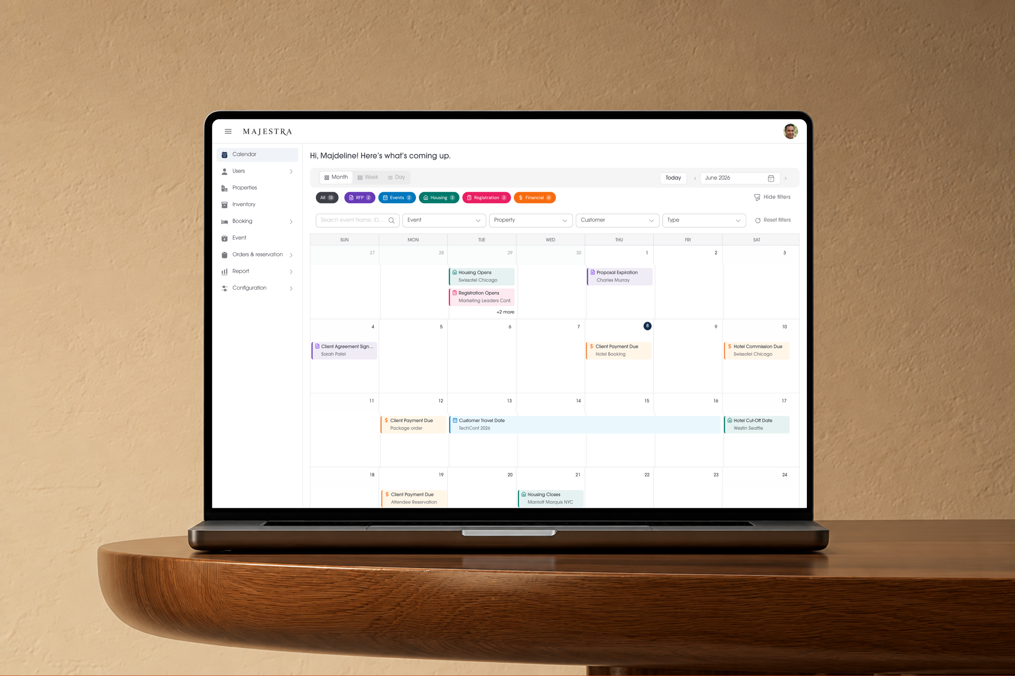 Laptop on a wooden table showing the Majestra calendar dashboard